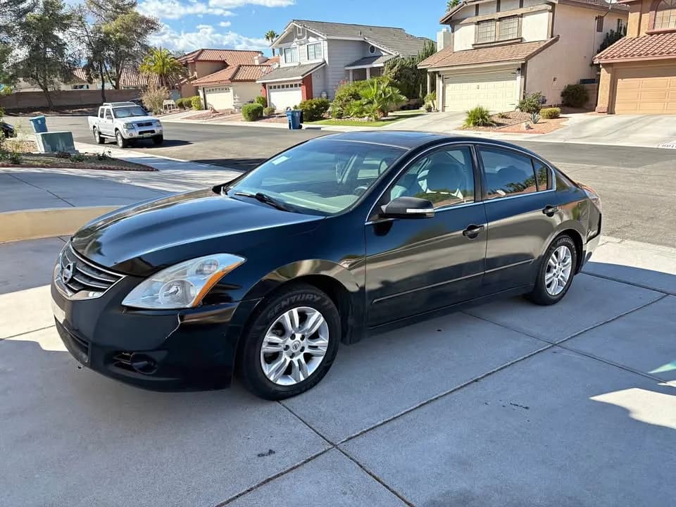 Black Nissan Altima sedan bought by Cash For Cars Nevada, parked in a residential driveway