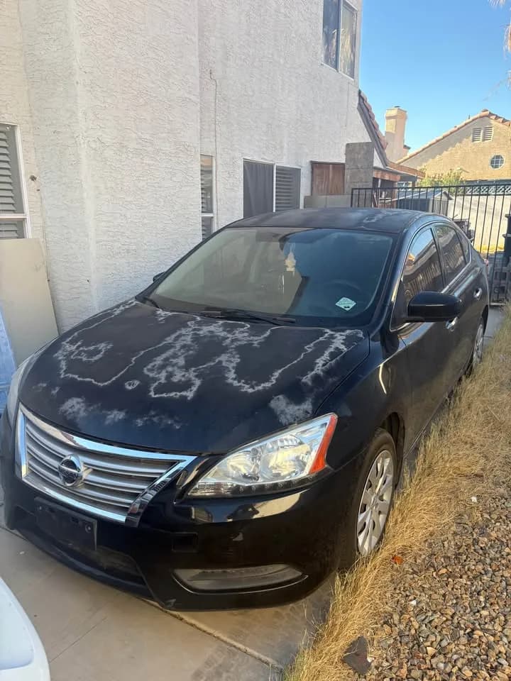 Black Nissan Sentra with sun-damaged, peeling paint, bought as-is by Cash For Cars Nevada