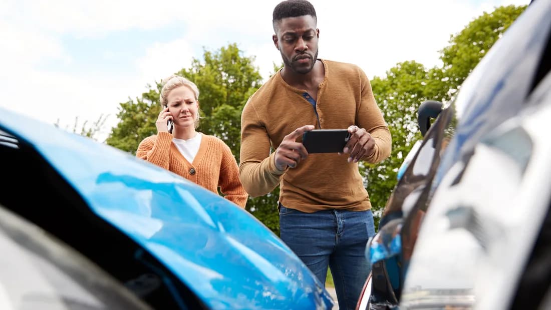 A driver photographing damage to two cars after an accident: what to do before you sell a car after an accident in Nevada