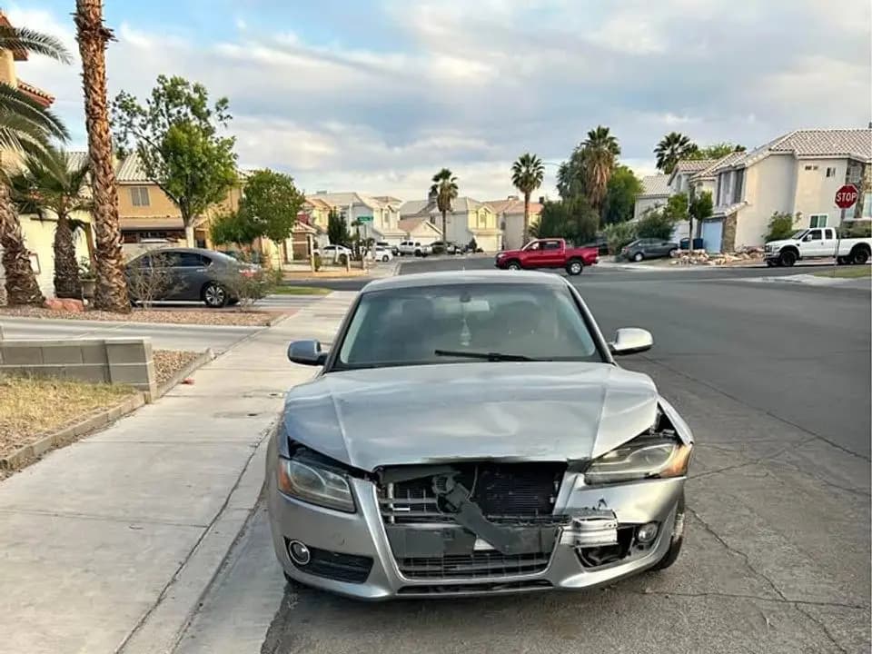 Silver 2010 Audi A5 coupe with its front bumper torn away, parked on a residential street