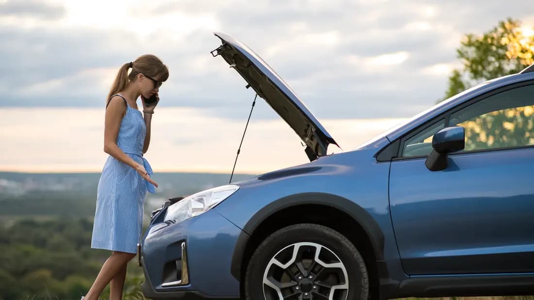Common questions about selling a car for cash in Nevada A woman standing beside her car with the bonnet raised at the roadside
