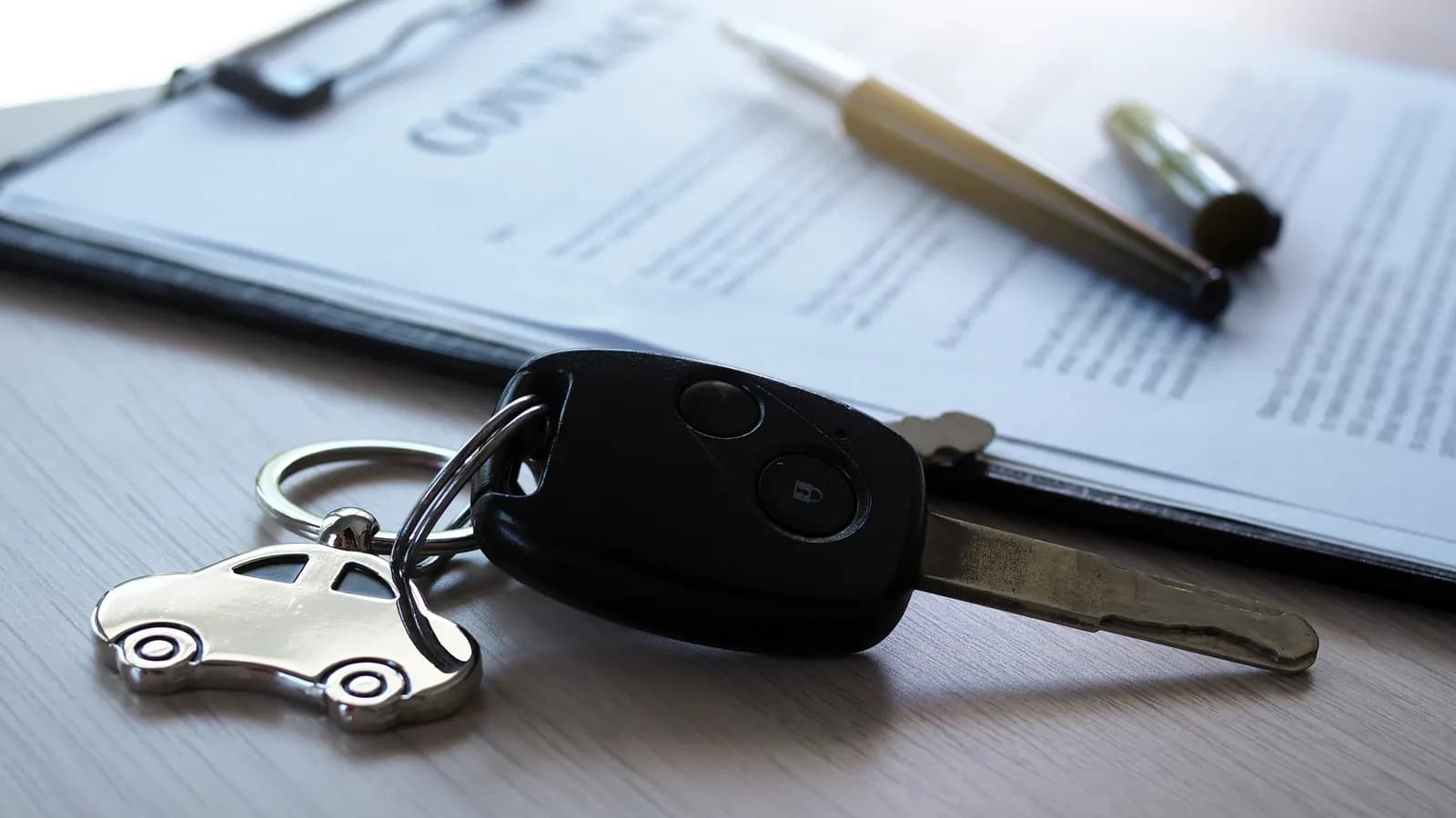 Car keys on top of the paperwork Car keys resting on car sale paperwork: selling a car that isn't in your name in Nevada