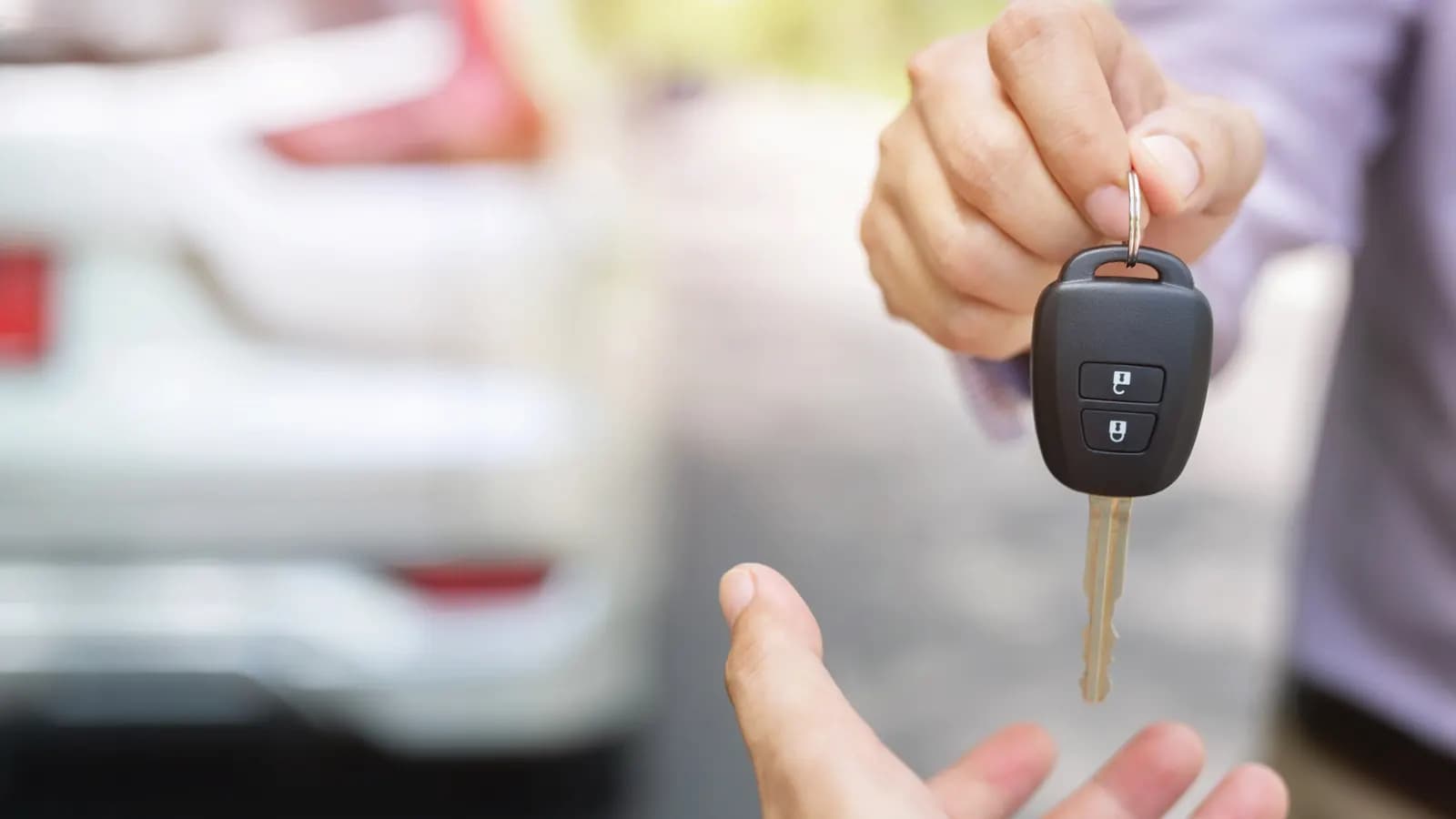Handing over the car key to the buyer A seller handing a car key to a buyer: selling a car to an out-of-state buyer from Nevada