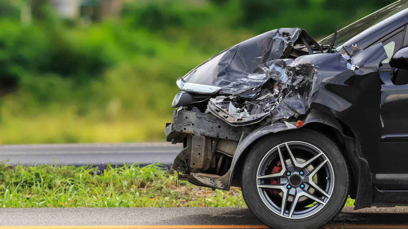A totaled car in Nevada: take the insurance payout or keep it and sell A black car with a crushed front end beside a road: a totaled car in Nevada, take the insurance payout or sell it